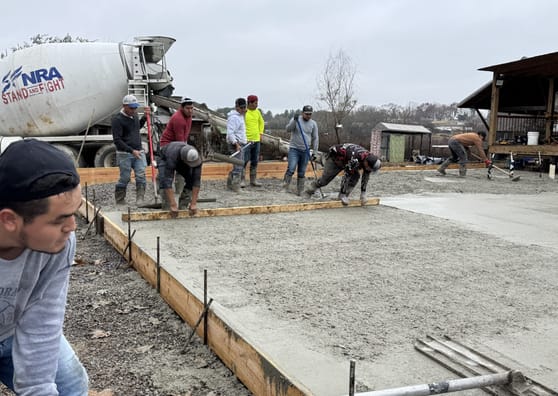 Mixer truck delivering concrete to a formed residential slab